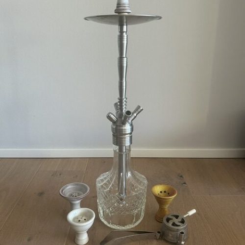 Verschiedene Shisha-Teile und Glasbowl auf Holzboden.