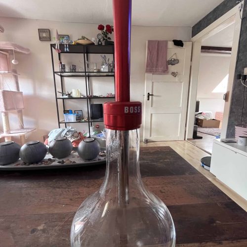 Wasserpfeife mit rotem Schlauch, Glasballon und BOSS-Logo, ideal für Shisha-Liebhaber.
