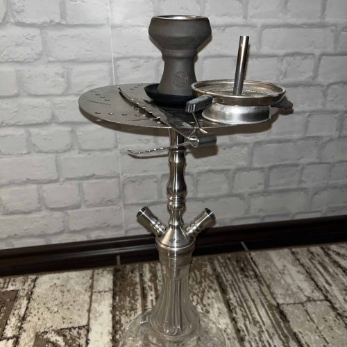 Shisha-Rauchsäule mit Tabakschüssel und Zubehör, auf einem Tisch.