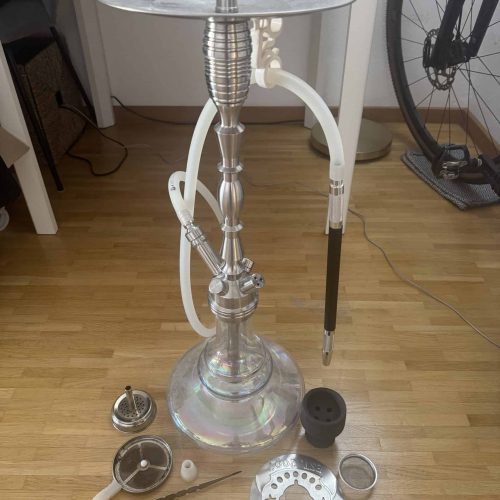 Moderne Shisha mit Glasbasis, Schlauch und Zubehör, auf Holzboden.