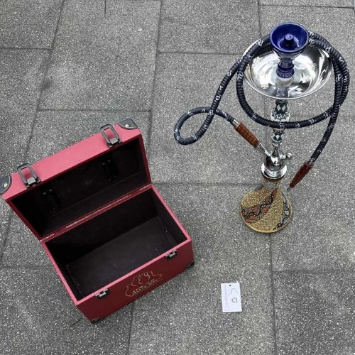 Shisha mit blauer Glasbowl und Transportkoffer auf Gehweg.