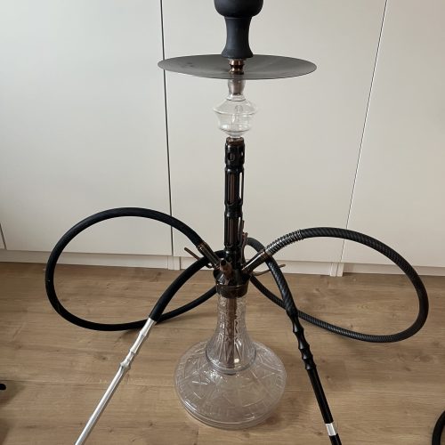 Shisha mit Glasbasis und Zubehör, auf Holzboden.