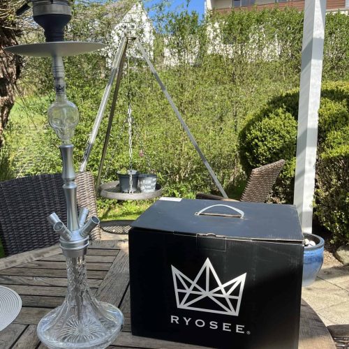 Rauch-Hookah mit Ryosee-Box auf einem Gartentisch, ideal für entspannte Abende im Freien.
