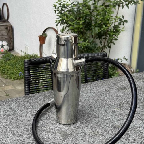 Stainless Steel Shisha Kopf mit flexiblem Schlauch auf Tisch.