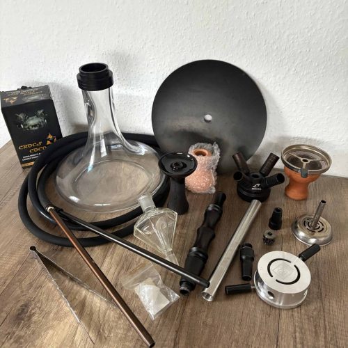 Verschiedene Shisha-Teile und Zubehör auf Holzoberfläche.