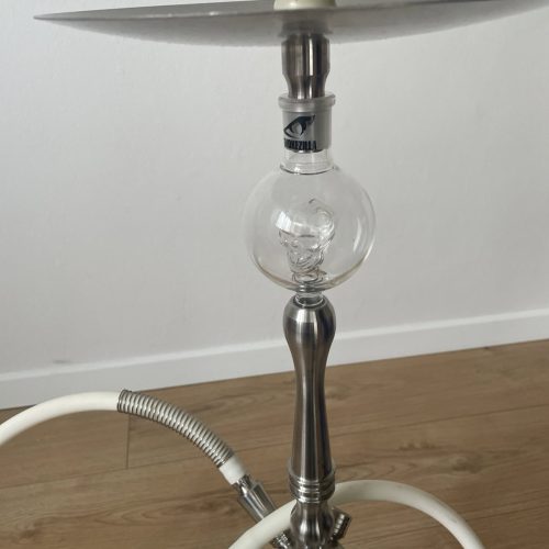 Shisha-Hookah mit Glasbowl und Metallständer auf Holzboden.