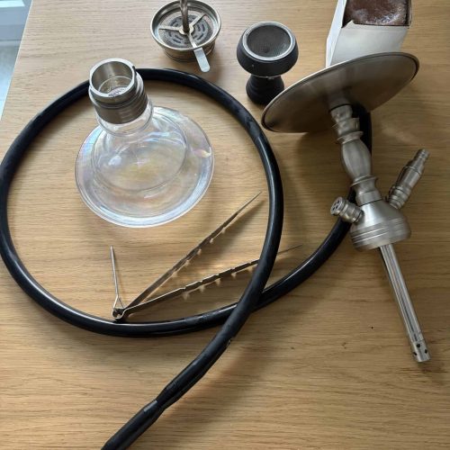 Shisha-Zubehör mit Glasbowl, Schlauch und Tabak in Verpackung.