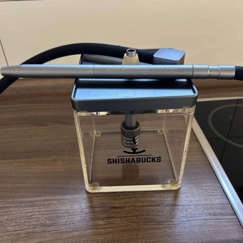Schlauch und Shisha-Container auf Holzoberfläche, bereit für den Gebrauch.