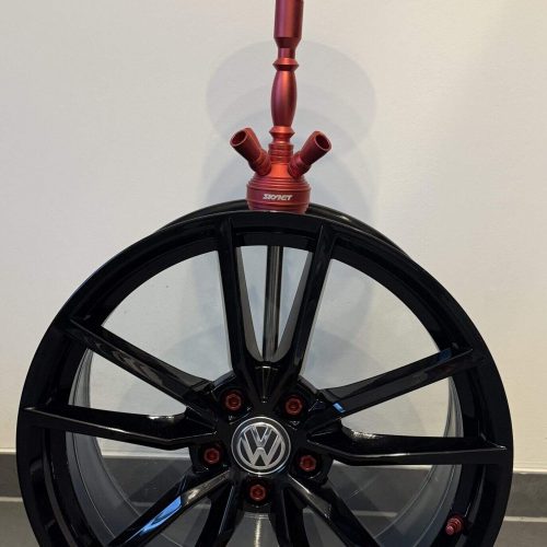 Altes VW Rad mit rotem Stehtisch, stilvoll und einzigartig, perfekt für Dekoration oder Sammler.