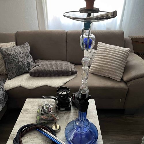 Moderne Shisha mit Glasbowl und Zubehör im Wohnzimmer.