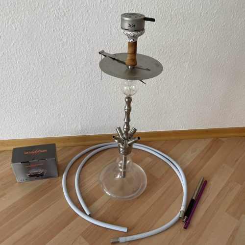 Shisha mit Glasbowl, Schlauch und Zubehör auf Boden.