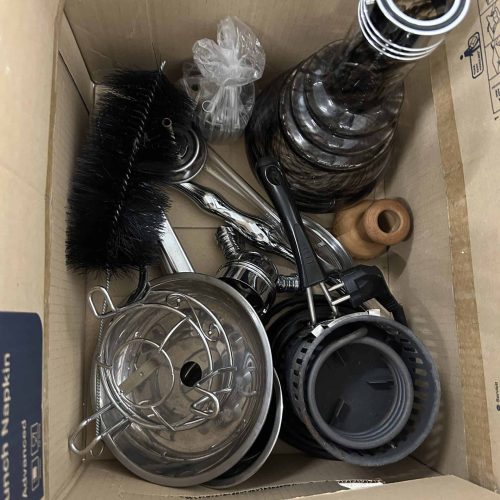 Verschiedene Shisha-Teile und Zubehör in Karton verpackt.