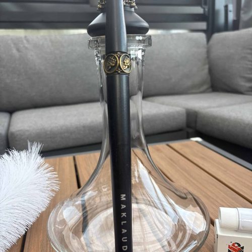 Moderne Shisha mit schwarzem Metallrohr und Glasbowl auf Holztisch.