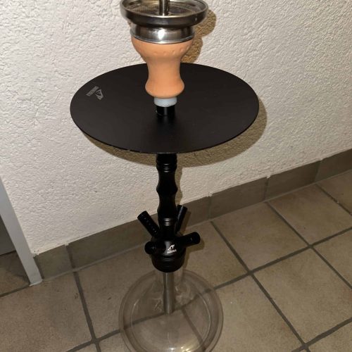 Rauchsäule mit Shisha-Setup auf einem Tisch, bereit zum Rauchen.