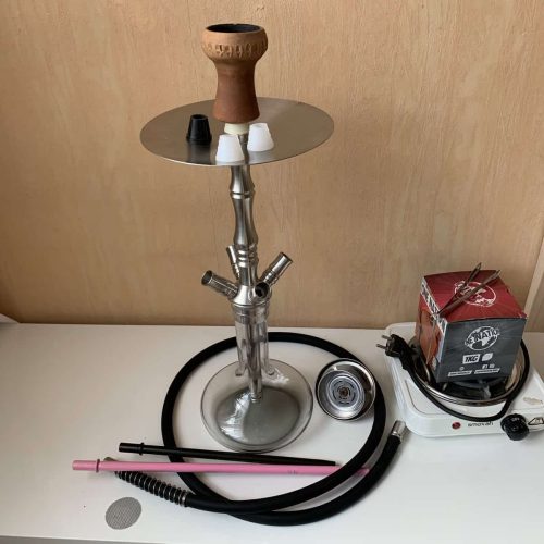 Rauchsäule und Shisha-Zubehör auf einem Tisch, bereit für den Gebrauch.