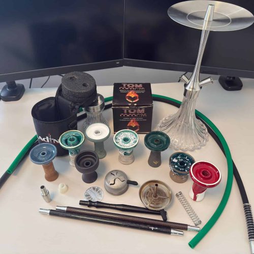 Verschiedene Shisha-Teile und Zubehör auf einem Tisch.