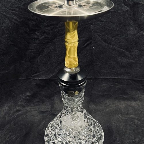 Shisha-Kopf mit Glasbasis, Metallplatte und gelbem Schlauchanschluss.