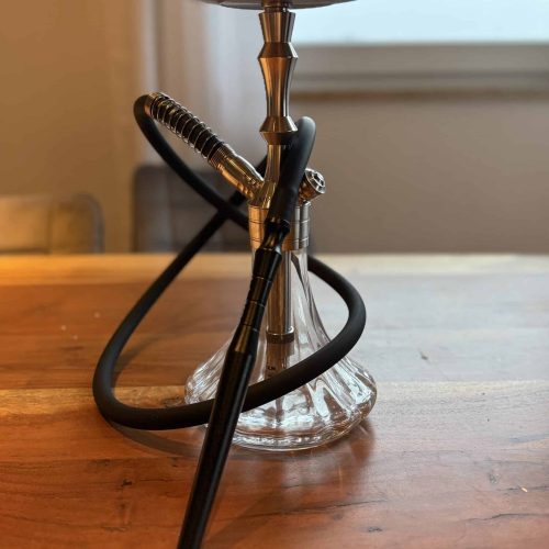 Shisha mit Glasbasis und Metallaufsatz, bereit zum Rauchen.
