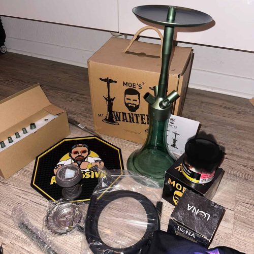 Rauchsäule mit Shisha, Zubehör und Verpackung auf Holzboden.