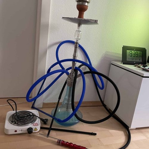 Rauchgerät mit Wasserpfeife, Schlauch und Heizgerät für Shisha-Genuss.