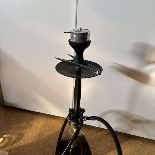 Shisha-Hose mit Zubehör auf einem Stand, bereit für den Gebrauch.