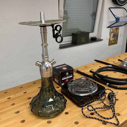 Wasserpfeife mit Glasbasis, Schlauch und Zubehör für Shisha-Genuss.