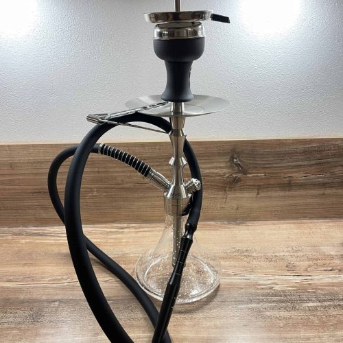 Shisha mit Glasbowl und Schlauch auf Holztisch.