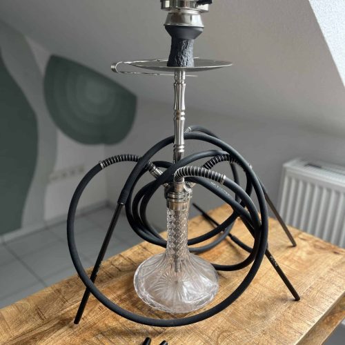 Rauchsäule für Shisha mit Schlauch, auf Holz Tisch, in Innenraum.