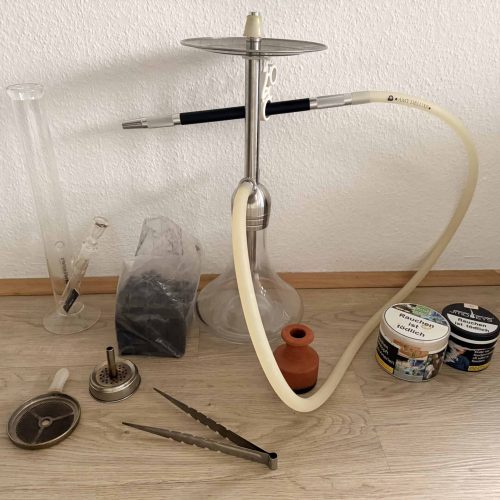 Zubehör für Shisha, inklusive Schlauch, Tabak, Zange und Kohle.