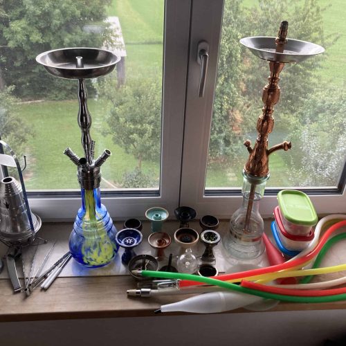 Verschiedene Shisha-Teile und Zubehör auf Fensterbank.