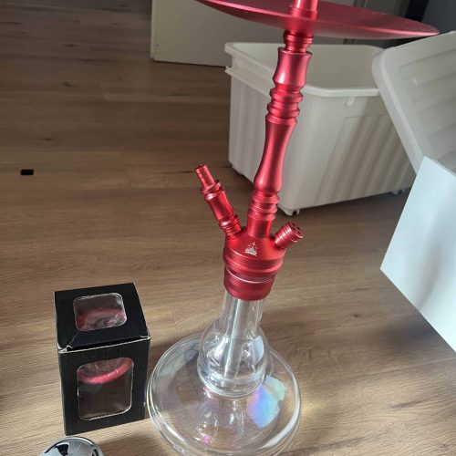 Rauch-Hookah mit rotem Metall und Glasbasis, ideal für Shisha-Liebhaber, auf einer Holztisch im Inne.