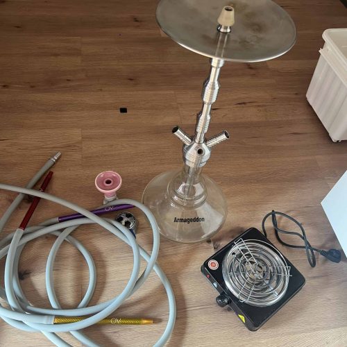 Shisha-Zubehör mit Heizgerät, Schlauch und Tabakbrenner auf Holzboden.