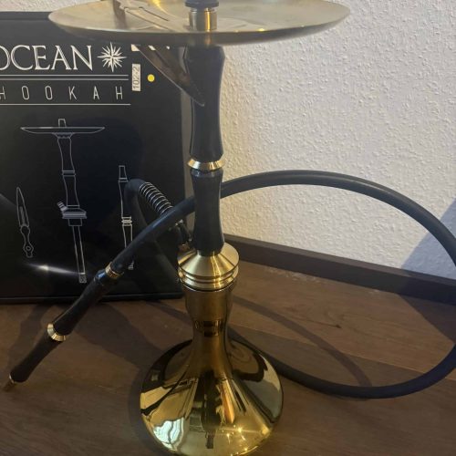 Schwarze Wasserpfeife mit goldener Basis und Metallplatte, ideal für Shisha-Liebhaber.