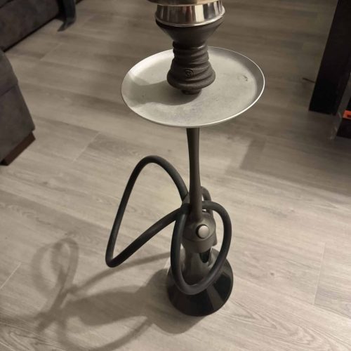 Rauchsäule mit Shisha-Tabak und Zubehör auf einem Tisch.