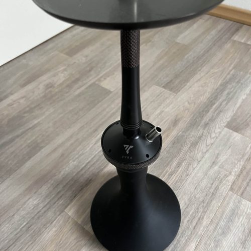 Schwarze Shisha-Halterung mit Ablagefläche auf Holzboden.