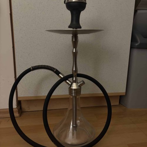 Rauchsäule mit Shisha-Setup, inklusive Schlauch und Kopf, auf Holzboden.