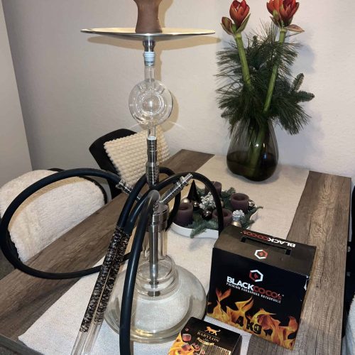 Dekorative Rauchsäule mit Shisha, Tabak und Feuerbox auf Esstisch.