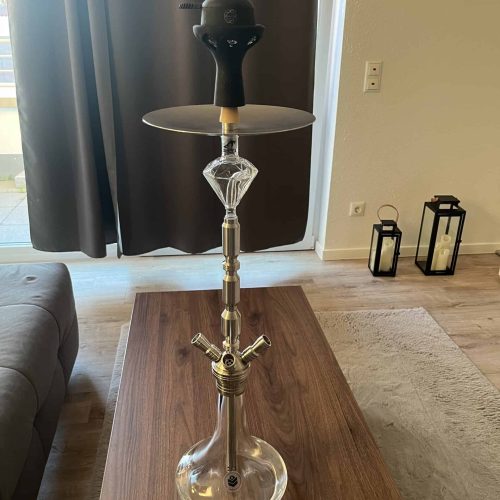Shisha mit Kopf und Zubehör auf einem Tisch in Wohnzimmer.