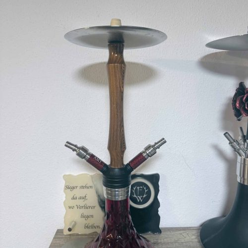 Shisha-Hookah mit Holzstamm und Glasbowl, auf Tisch.