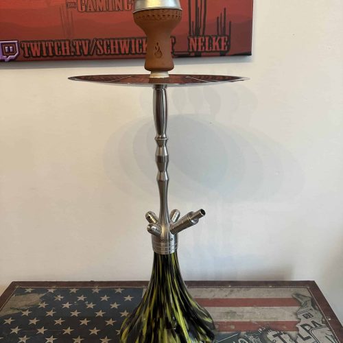 Shisha-Rauchsäule mit Glasbasis und Kopf, auf Tisch stehend.