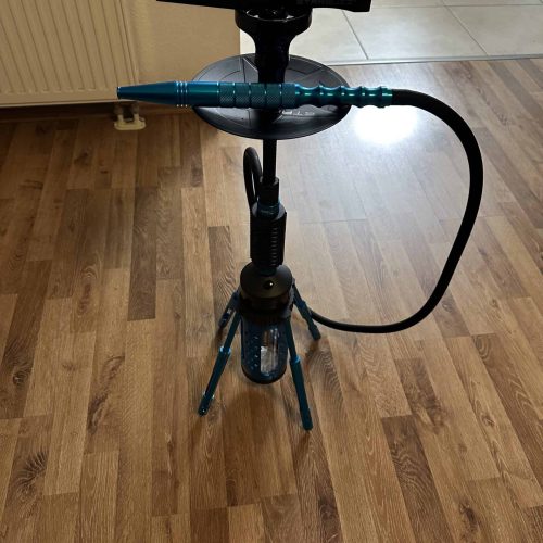 Shisha-Zubehör mit Schlauch, Zange und Standfuß auf Holzboden.