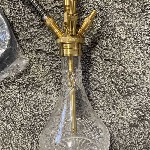 Elegante Glas-Shisha mit goldenen Akzenten und Schlauch, ideal für Genuss.