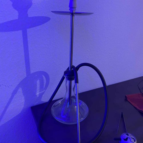 Shisha mit blauer LED-Beleuchtung, auf einem Tisch stehend.