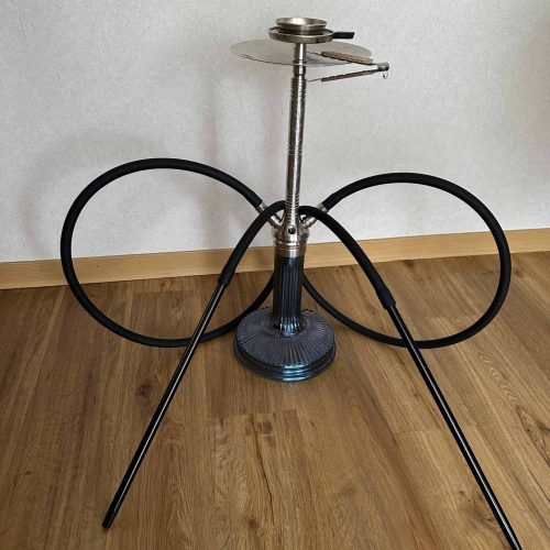 Shisha-Kopf mit Glasbowl und Schläuchen auf Holzboden.