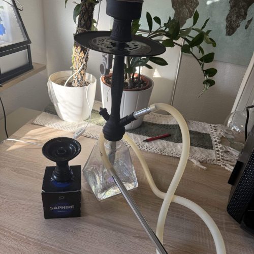 Wasserpfeife (Shisha) mit Glasbasis, Schlauch und Tabakzubehör.
