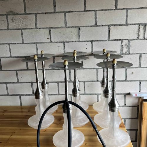 Mehrere Shisha-Köpfe auf einem Holztablett, bereit zum Rauchen. Perfekt für gesellige Abende.