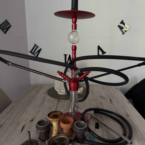 Moderne Shisha mit Glasbowl und Zubehör auf Tisch.