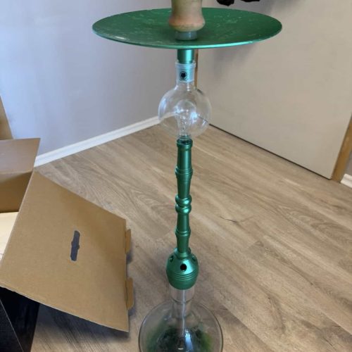 Hookah mit Glas- und Metallteilen, auf Holzboden, ohne Schläuche.