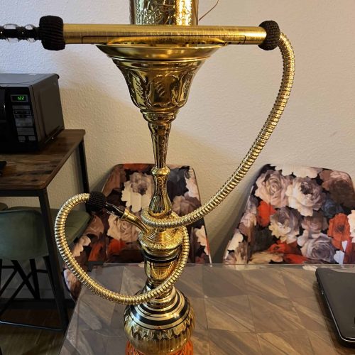 Große Shisha mit goldener Dekoration und Schlauch.