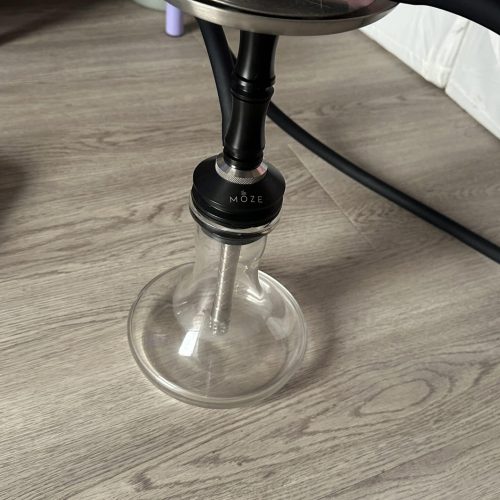 Shisha mit Glasbowl, Silikonschlauch und Metallaufsatz auf Holztisch.